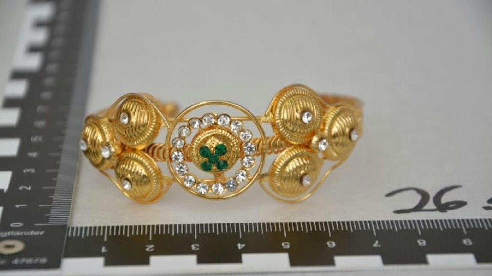 Das Bild zeigt einen goldfarbenen Armreif.