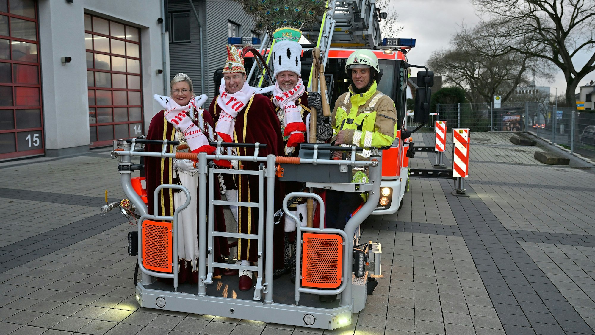 Das Bergisch Gladbacher Dreigestirn steht im Korb einer Feuerwehrdrehleiter.