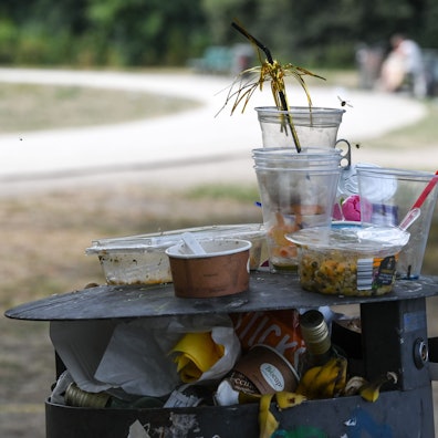 Ein übervoller Mülleimer mit Einwegverpackungen.