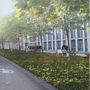 Ein Fahrstreifen mit dem Piktogramm für Radfahrer ist zu sehen. Links sind die Stelzen der Hochbahn, rechts ein Grünstreifen, dahinter ein Gebäude.