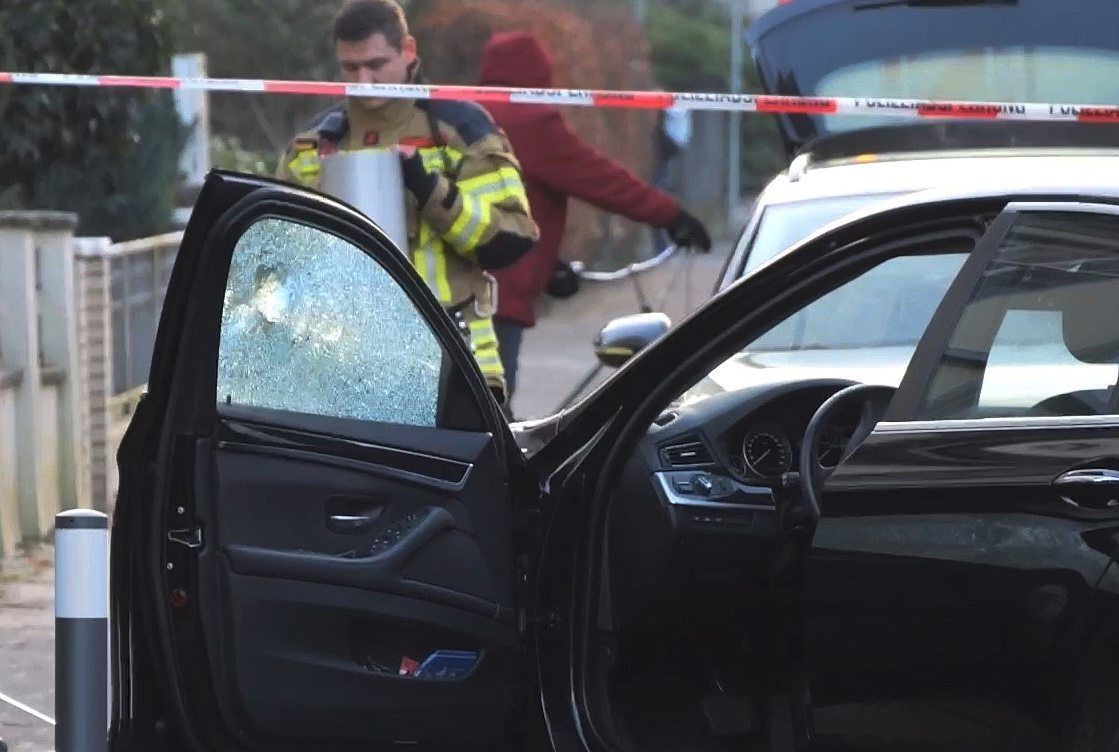 Ein PKW, an dem die Beifahrer-Scheibe ein Loch hat, wird untersucht.