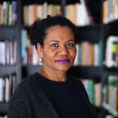 Glenda Obermuller steht vor einem Regal mit Schwarzer Literatur