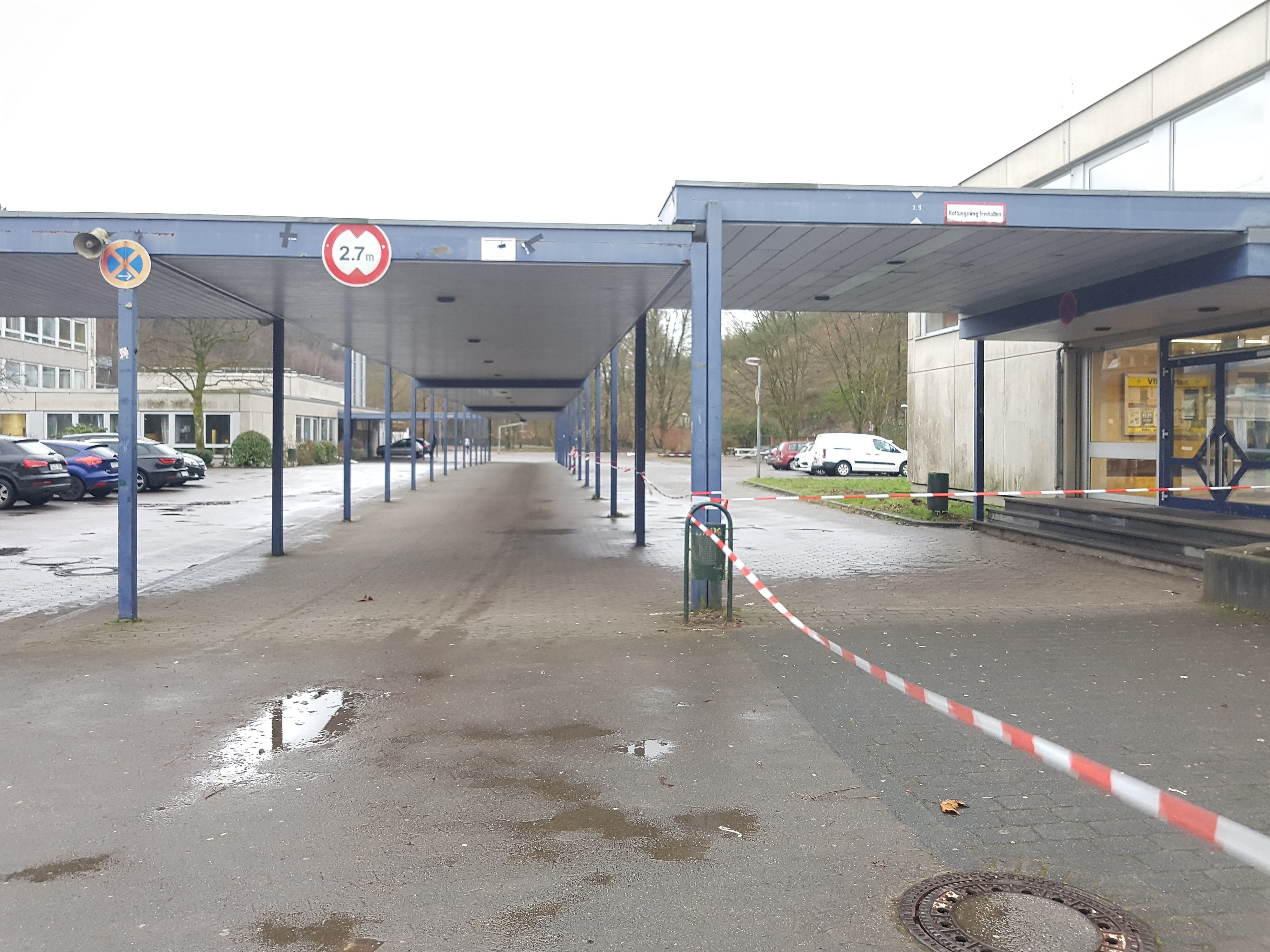 Blick auf ein Schulzentrum. Ein Absperrband flattert zwischen den Laubengängen. (Symbolbild)