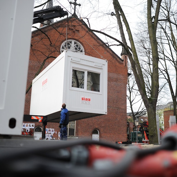 Ein Container hängt an einem Kram und wird abgesetzt.