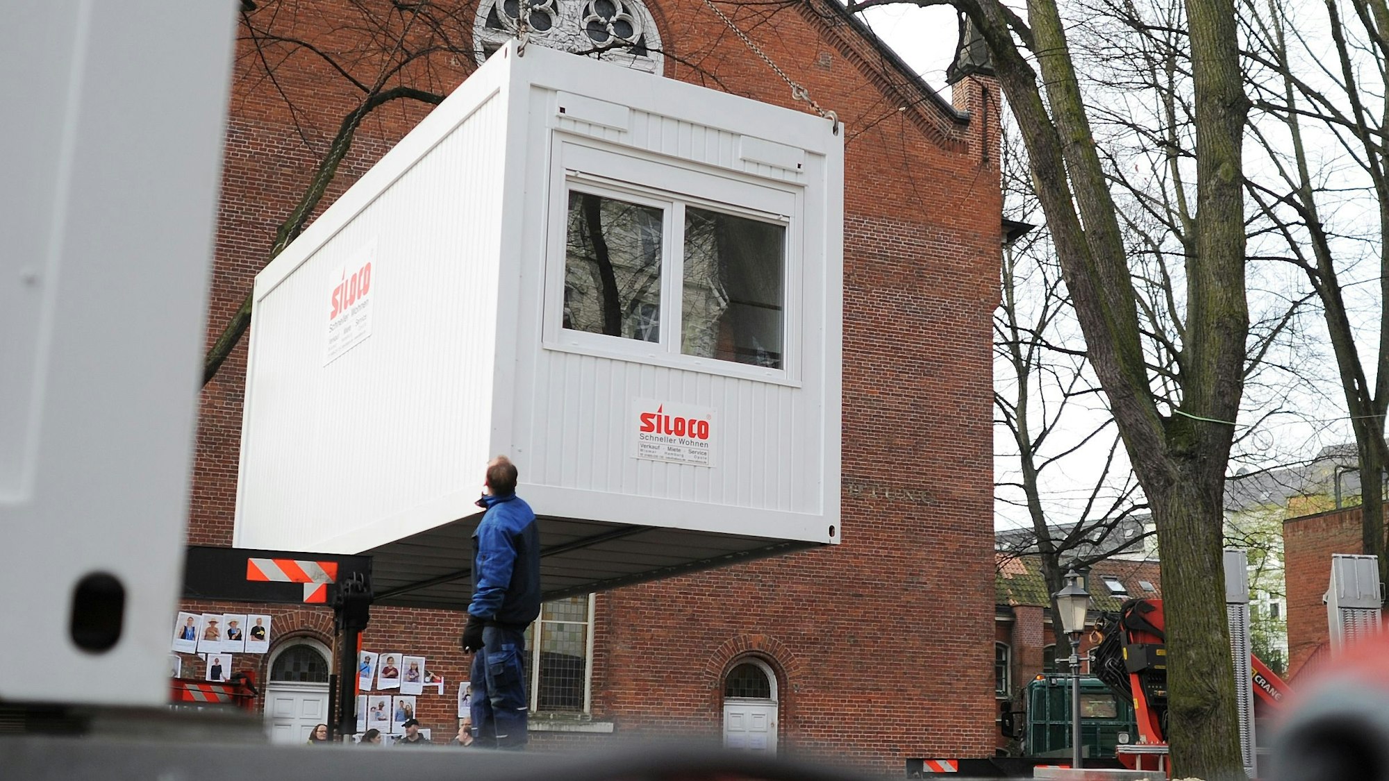 Ein Container hängt an einem Kram und wird abgesetzt.