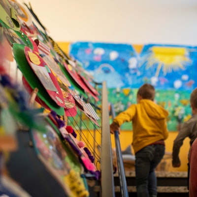 Für drei Monate sollen die Kindergärten der Kolpingstadt früher schließen und später öffnen. Das Foto zeigt Kinder in einer Einrichtung, sie gehen eine Treppe hinauf.