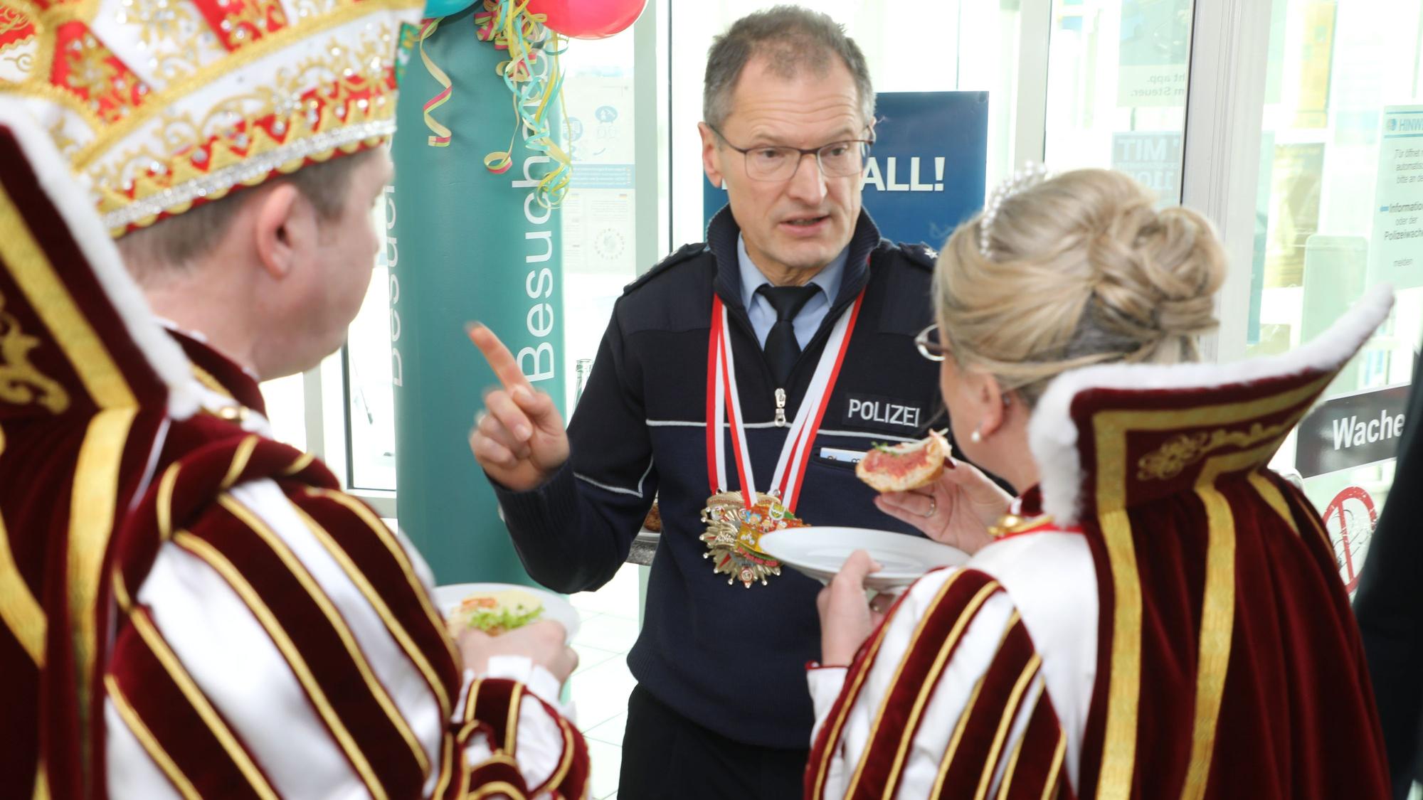 Der Polizeibeamte Norbert Wette spricht mit dem Karnevalsprinz Frank III. und der Jungfrau aus dem Dreigestirn, Melanie .