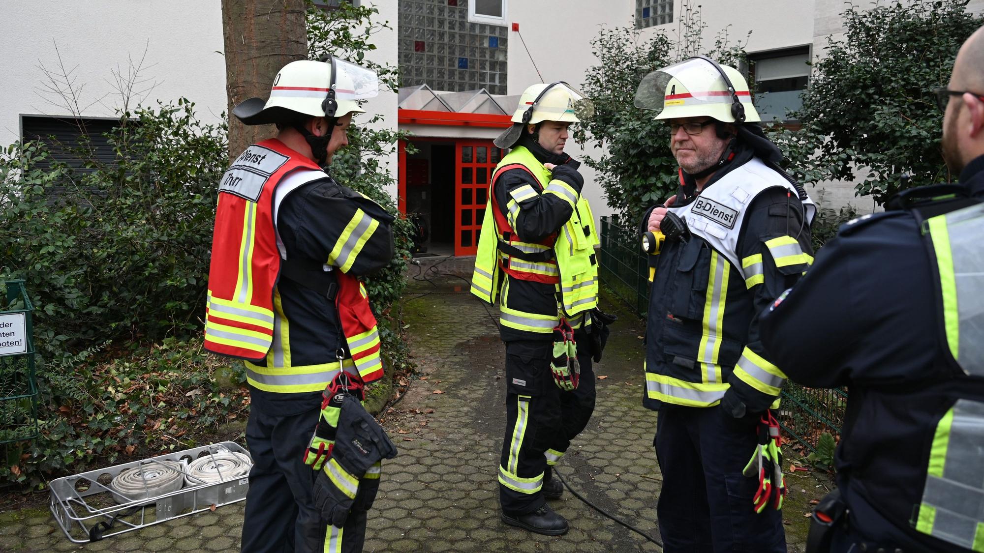 Man sieht Einsatzkräfte vor einem Haus stehen.