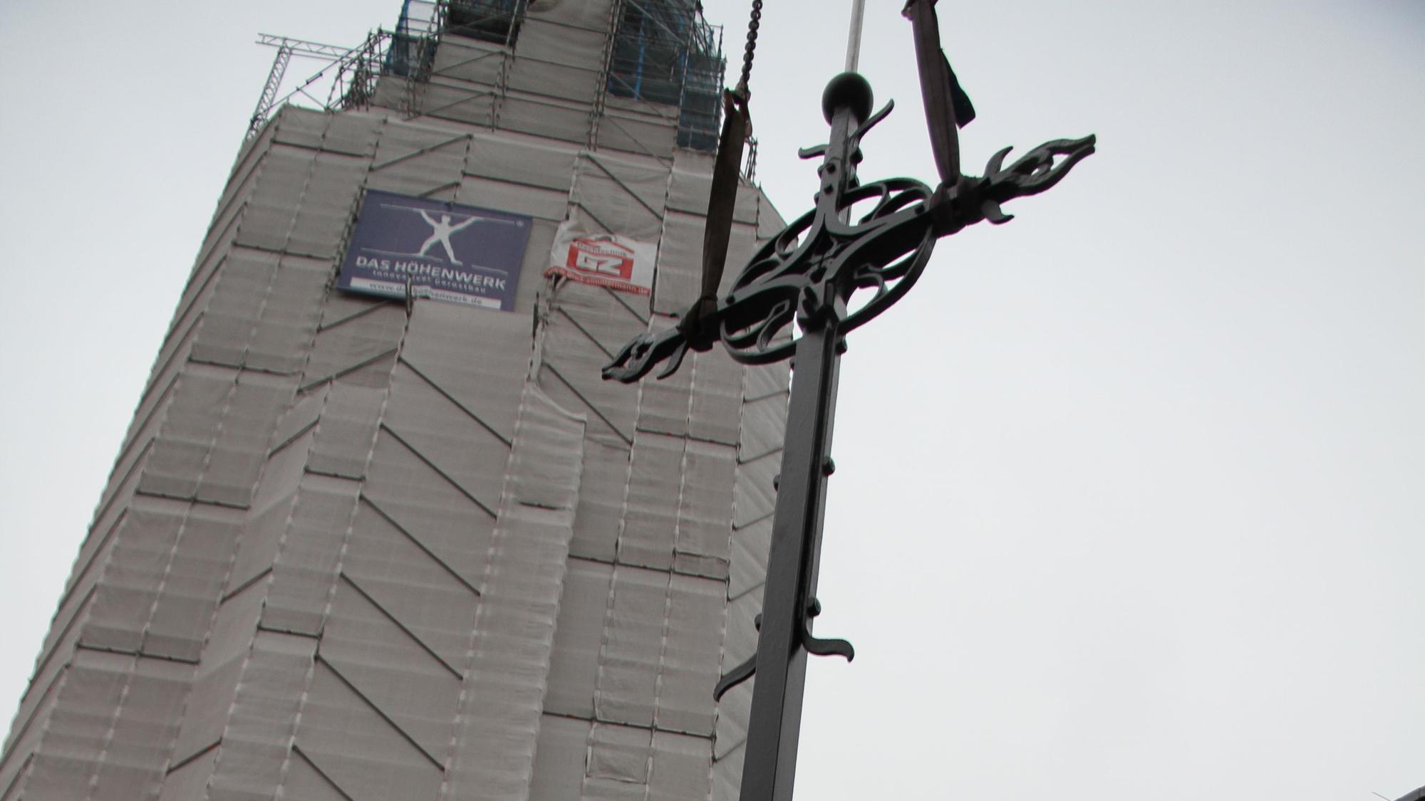 Der Turm der Kiche St. Anno in der Siegburger Nordstadt wird saniert, das Kreuz wurde jetzt wieder montiert.