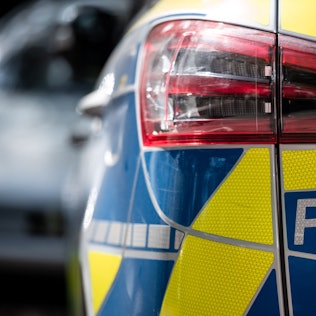 Das Foto zeigt einen Polizeiwagen von hinten. Die Polizei im Rhein-Erft-Kreis fahndet nach Tätern, die in Frechen und Bedburg Luxus-Autos gestohlen haben.