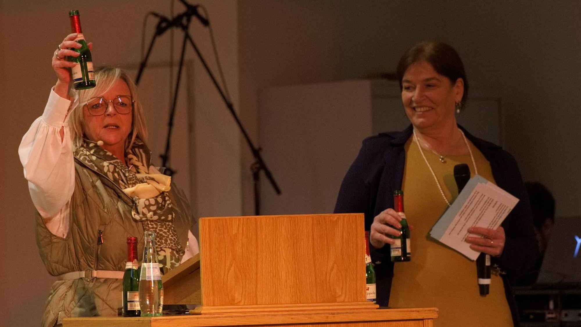 Bürgermeisterin Sabine Preiser-Marian (l.) und Moderatorin Martina Lanzrath stoßen mit einem Fläschchen Sekt auf das Erreichte an.