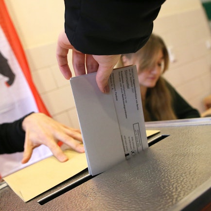 Eine Frau gibt ihre Stimme für die Wahl zum Berliner Abgeordnetenhaus ab und wirft ihren Wahlzettel in die Wahlurne.