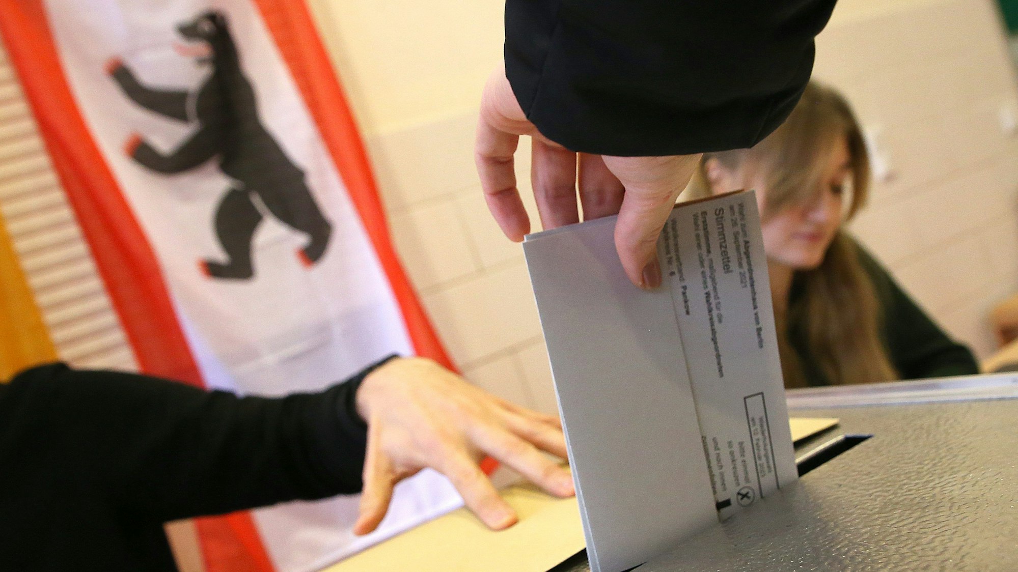 Eine Frau gibt ihre Stimme für die Wahl zum Berliner Abgeordnetenhaus ab und wirft ihren Wahlzettel in die Wahlurne.