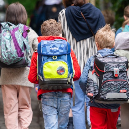 Schulkinder gehen in die Schule.