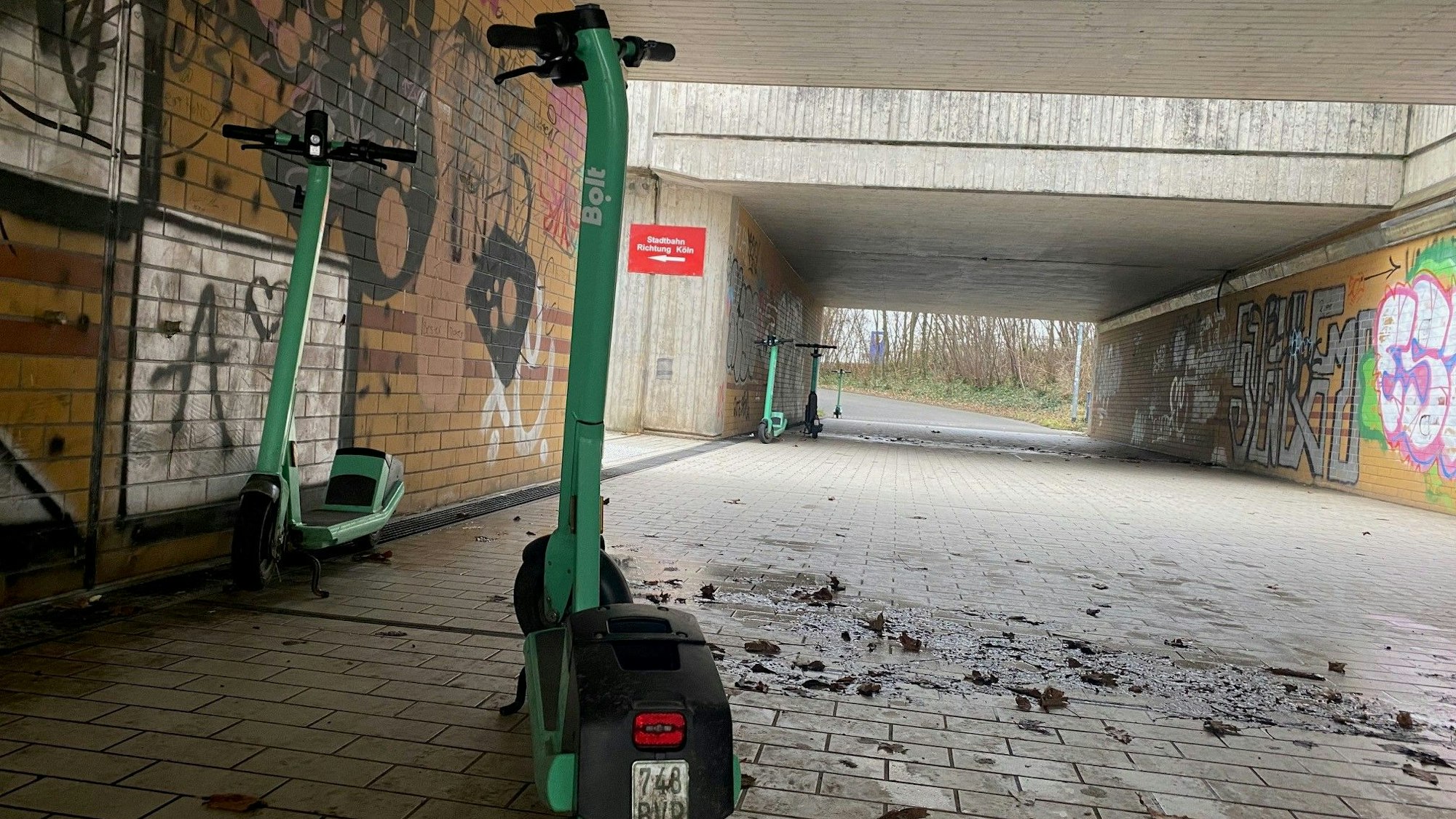 In einer Unterführung stehen mehrere Leih-E-Scooter.