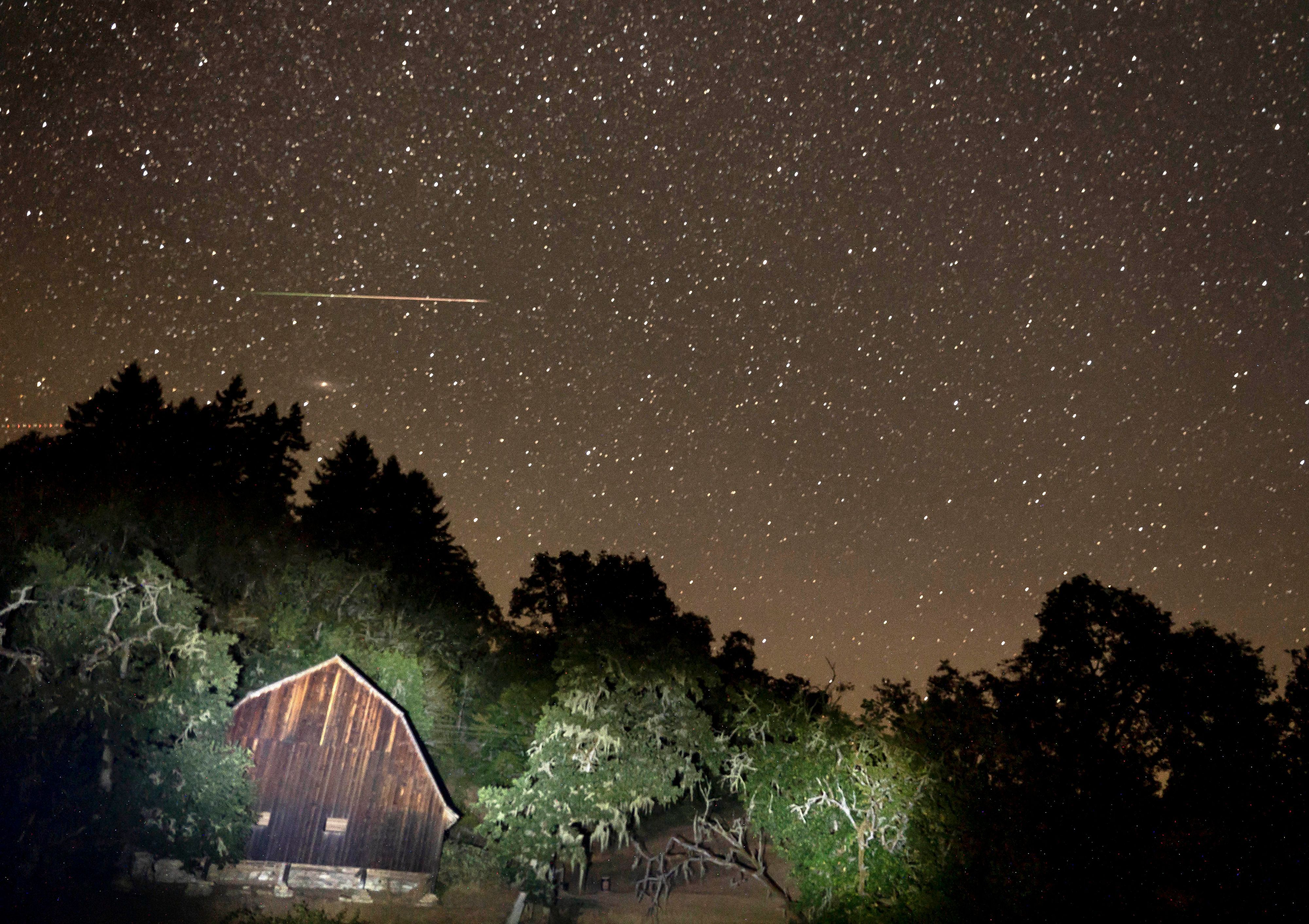 Ein Meteor des Perseiden-Meteoritenschauers zieht am Himmel über einer Scheune an einer Landstraße im ländlichen Westen Oregons vorbei. (Symbolbild)