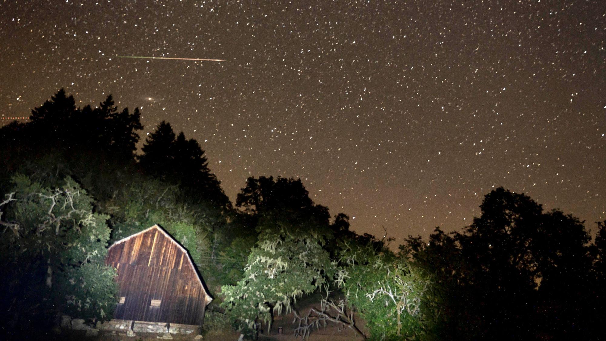 Ein Meteor des Perseiden-Meteoritenschauers zieht am Himmel über einer Scheune an einer Landstraße im ländlichen Westen Oregons vorbei. (Symbolbild)