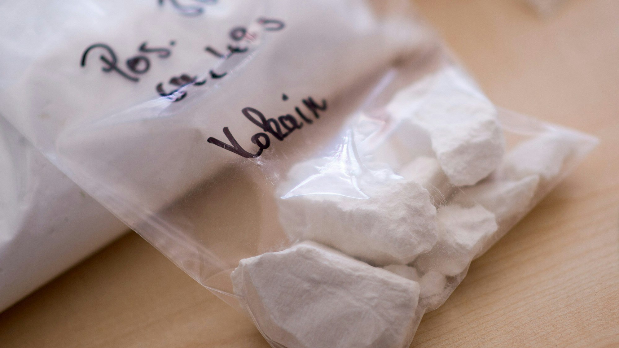 Ein Beutel mit Kokain liegt auf einem Tisch.