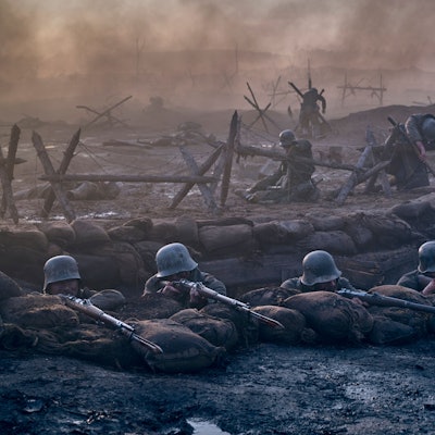 Eine Filmszene: Soldaten liegen mit angelegten Gewehren in einem Schützengraben.