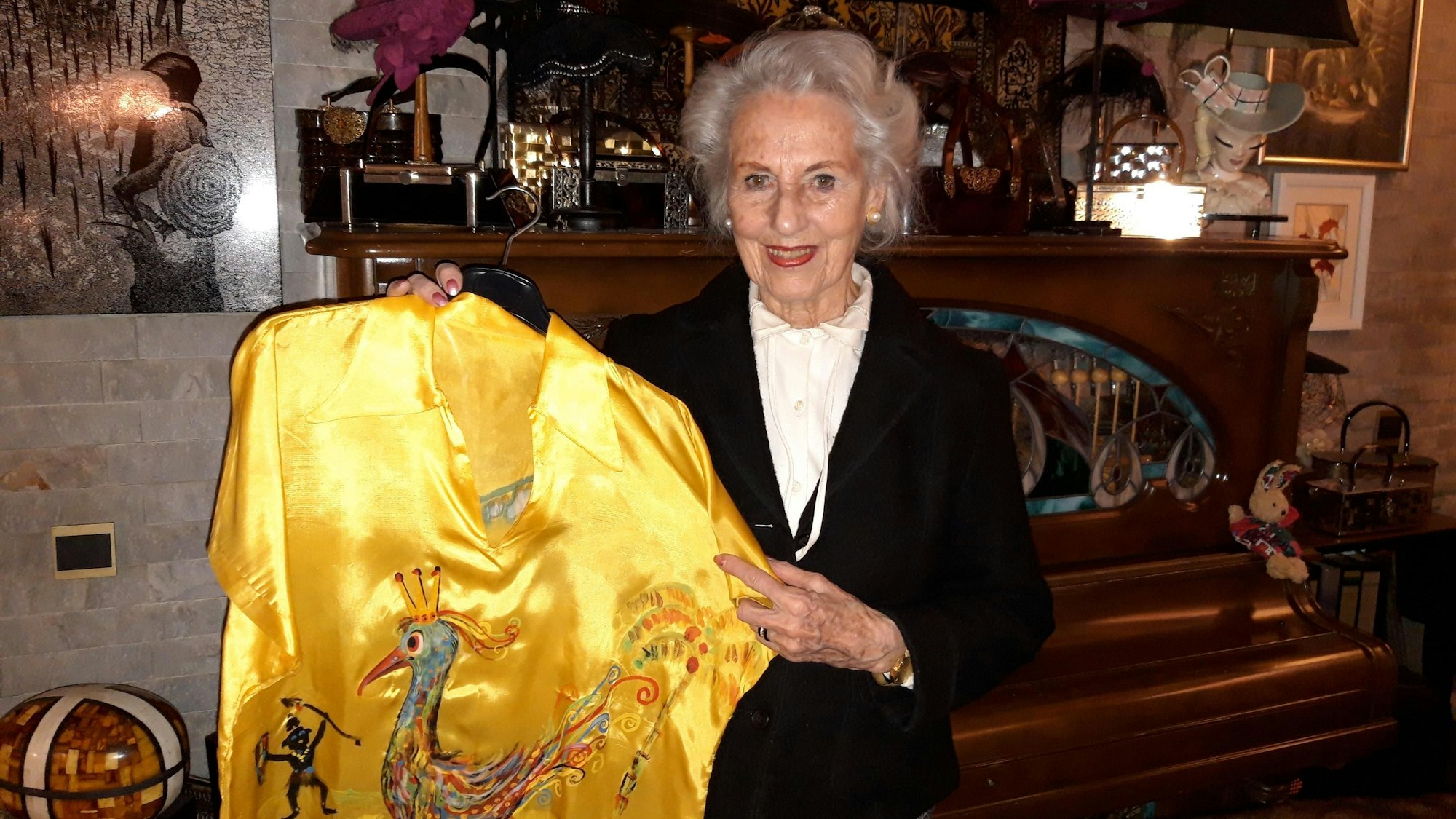 Melitta Erven hält die gelbe Bluse hoch, die Wolf Vostell für sie karnevalistisch bemalt hat.