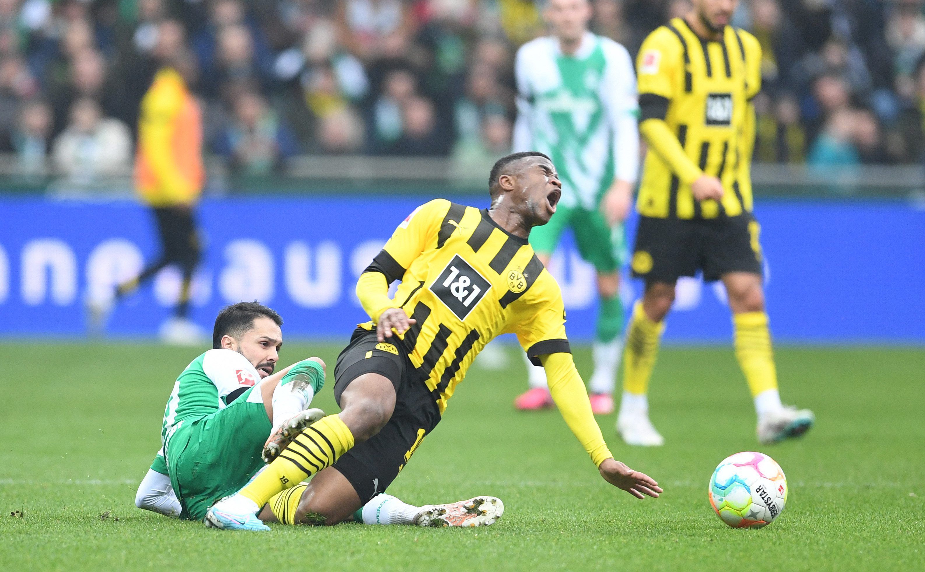 Dortmunds Youssoufa Moukoko (r) wird von Werders Leonardo Bittencourt gefoult.