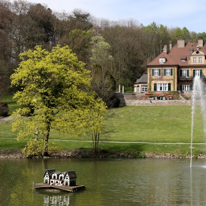 Schloss Lerbach mit Grünanlage und Teich davor.