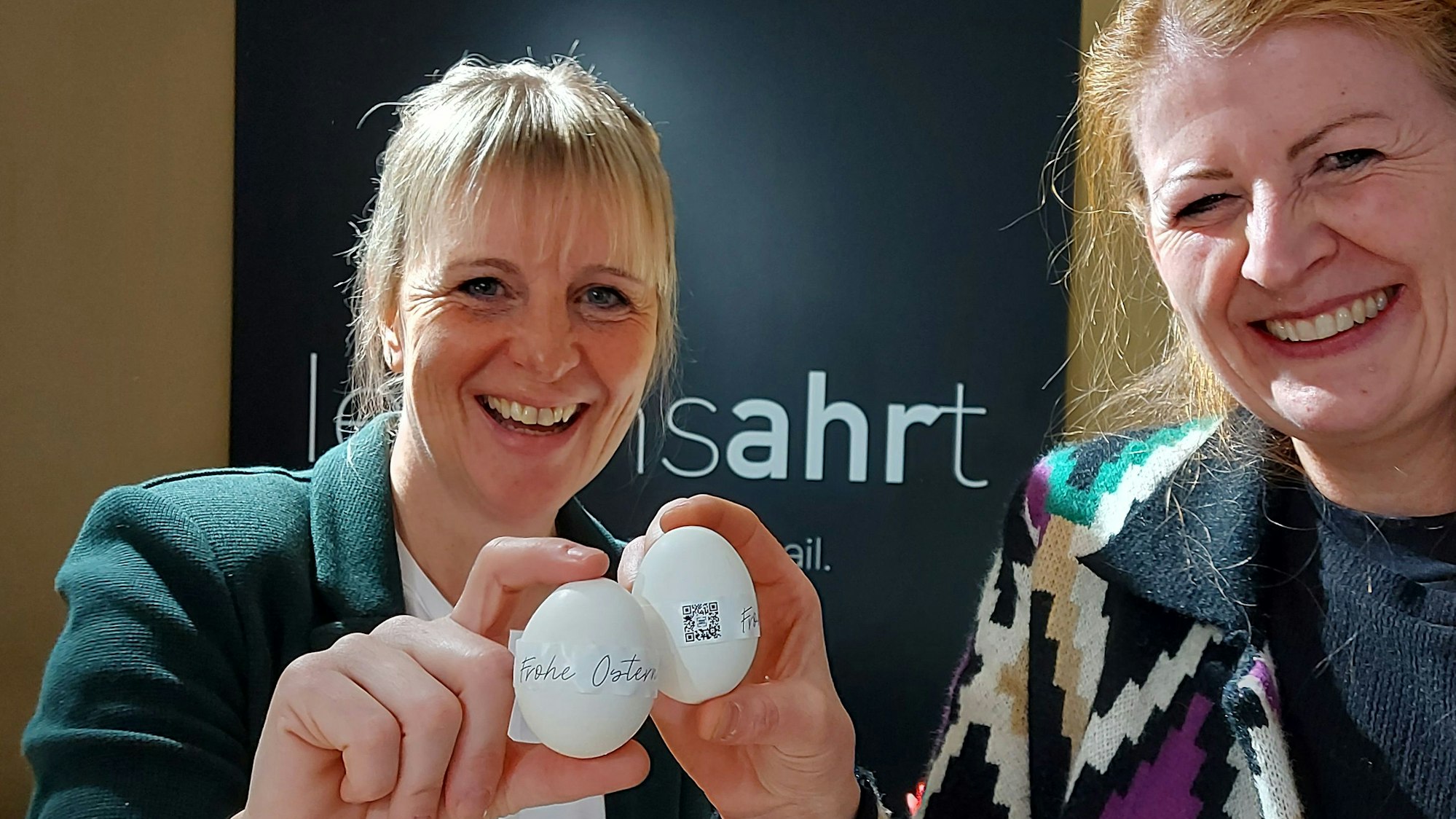 Anja Keul und Judith Maur halten nummerierte Hühnereier in der Hand.