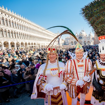 Auftritt auf dem Markusplatz: Das Dreigestirn der Roten Funken grüßt die Feiernden im italienischen Venedig.