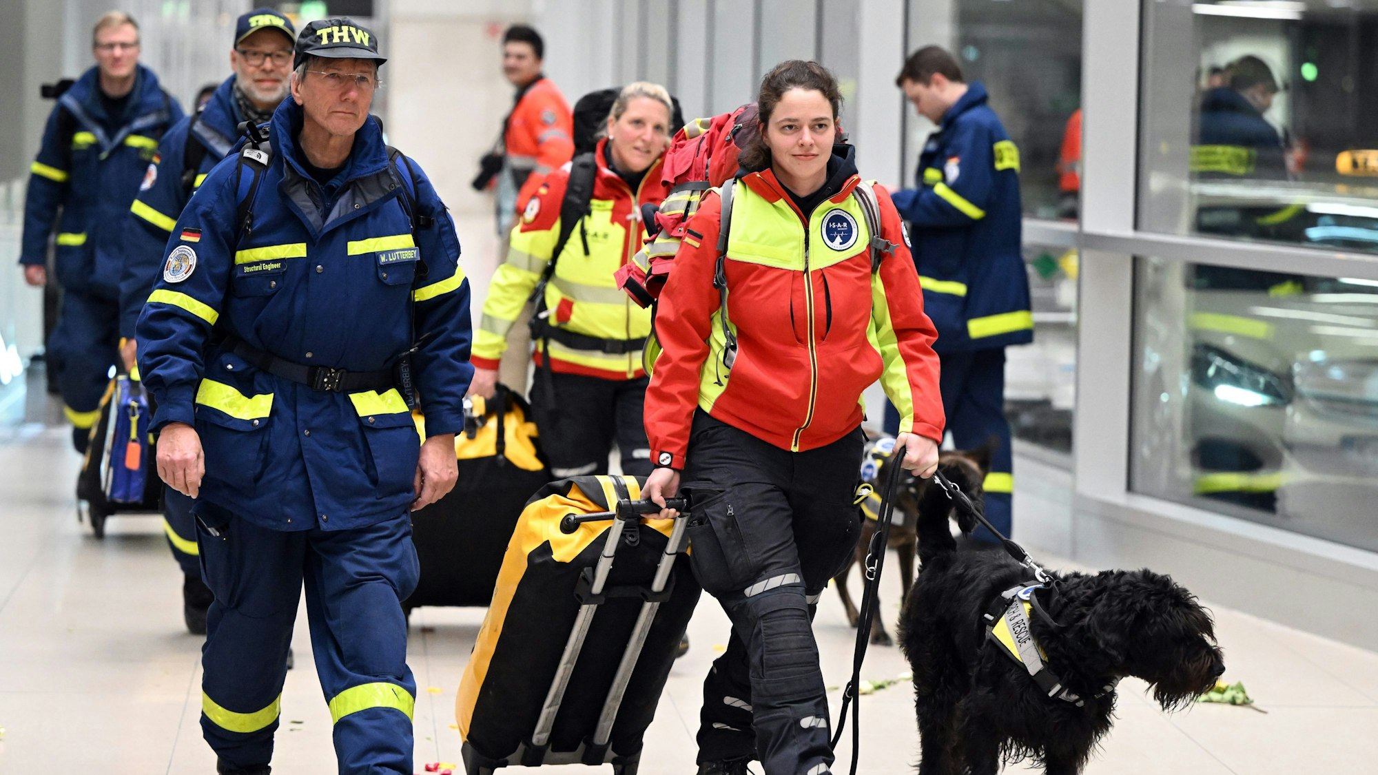 Rettungskräfte werden von jubelnden Menschen auf dem Flughafen in Köln begrüßt.