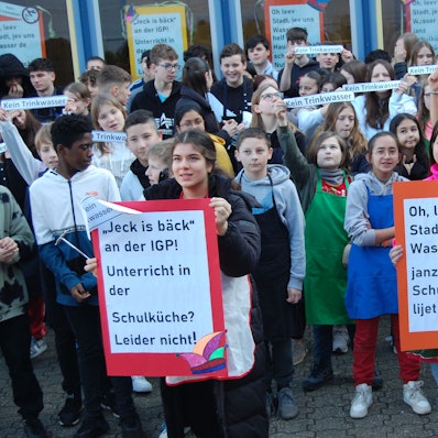 Schüler des Hauswirtschaftsunterrichts der Integrierten Gesamtschule Paffrath (IGP) protestieren mit Schildern.