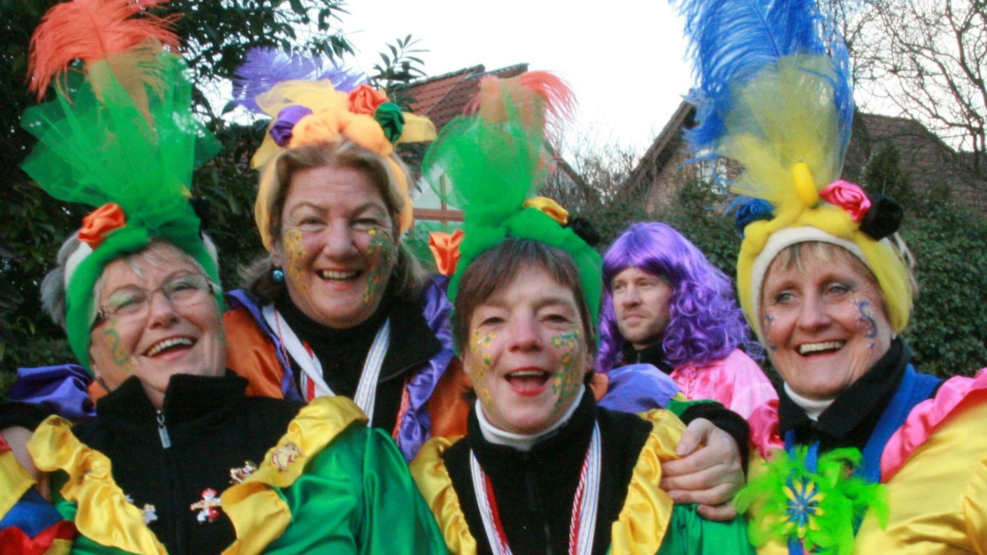 Vier Frauen in Kostümen lachen in die Kamera.