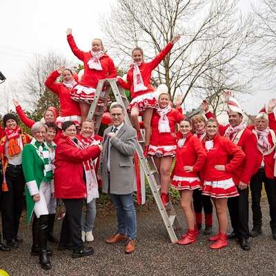 Eine Gruppe Karnevalisten steht mit dem Nettersheimer Bürgermeister vor dem Rathaus.