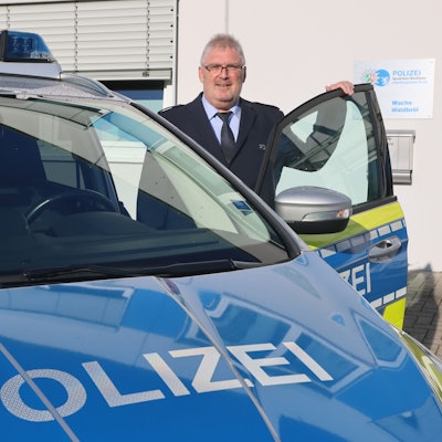 Der neue Wachleiter Falko Steinhauer steht an einem Streifenwagen.