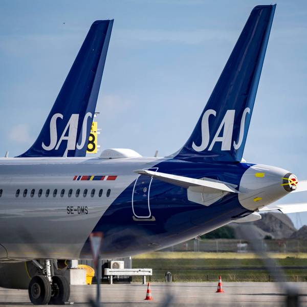 Zwei Airbus A320 der norwegischen Fluggesellschaft SAS stehen neben einer gelben Passagiertreppe. (Symbolbild)
