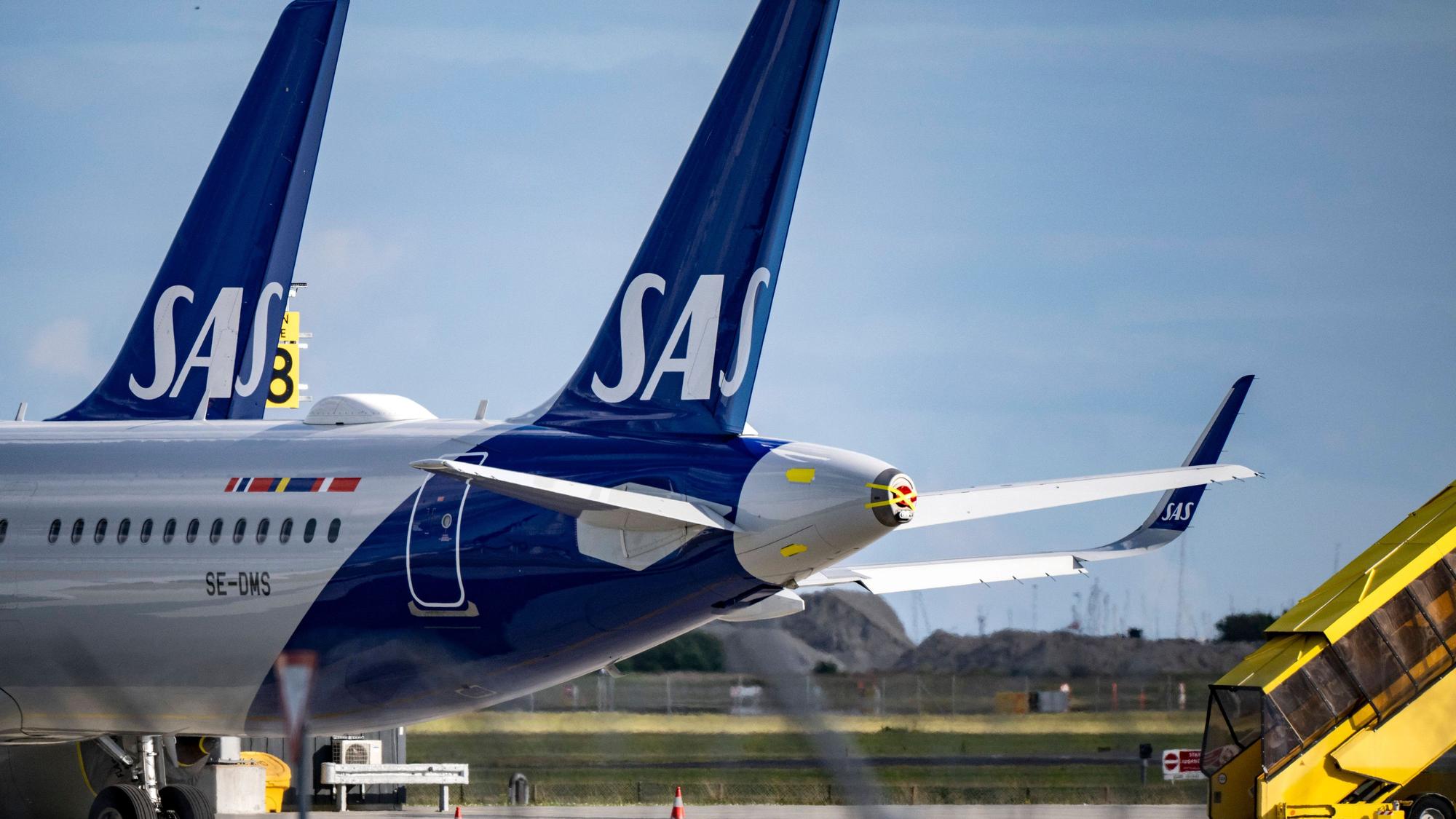 Zwei Airbus A320 der norwegischen Fluggesellschaft SAS stehen neben einer gelben Passagiertreppe. (Symbolbild)