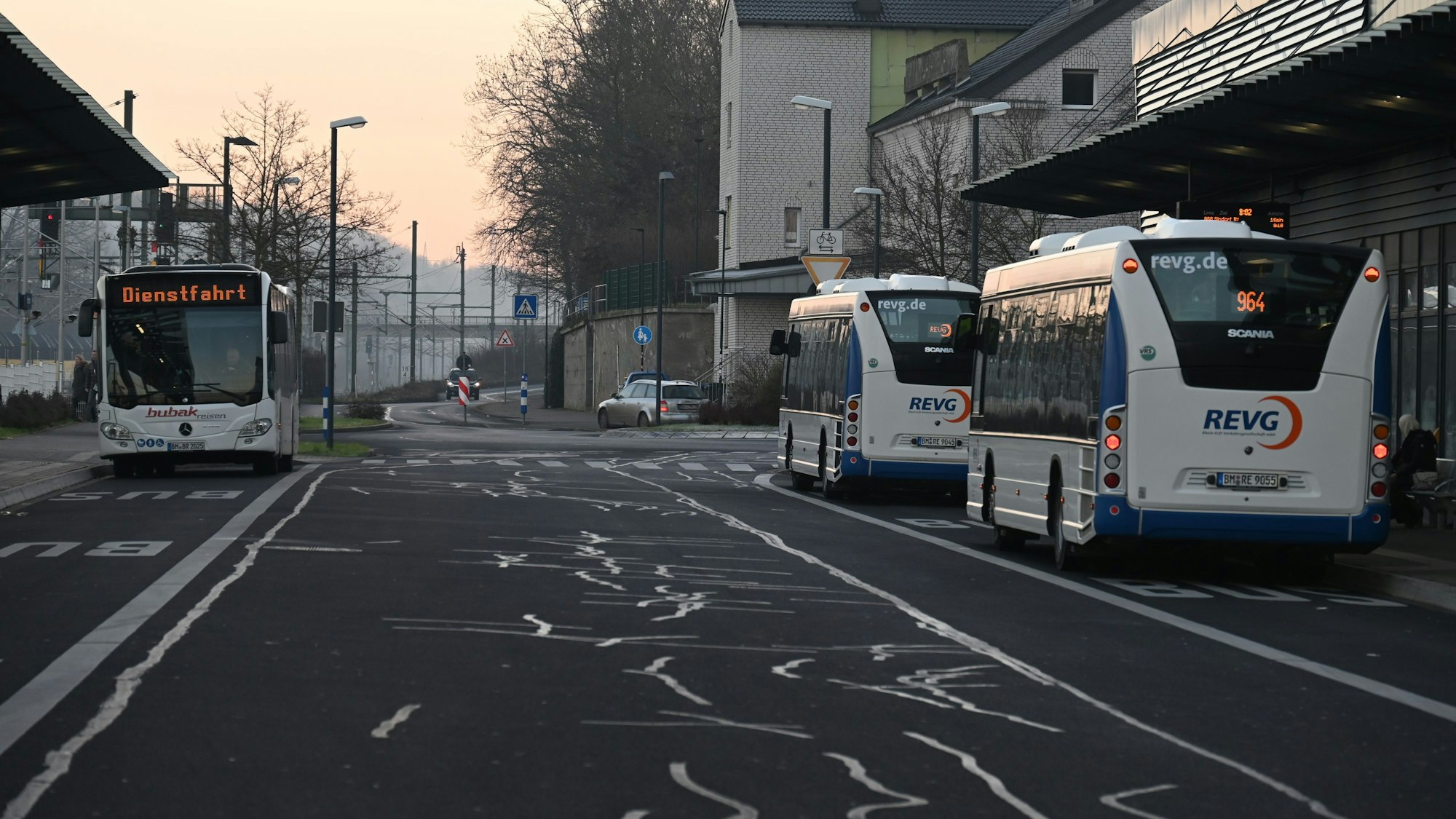 Drei Busse stehen an einem Busbahnhof.