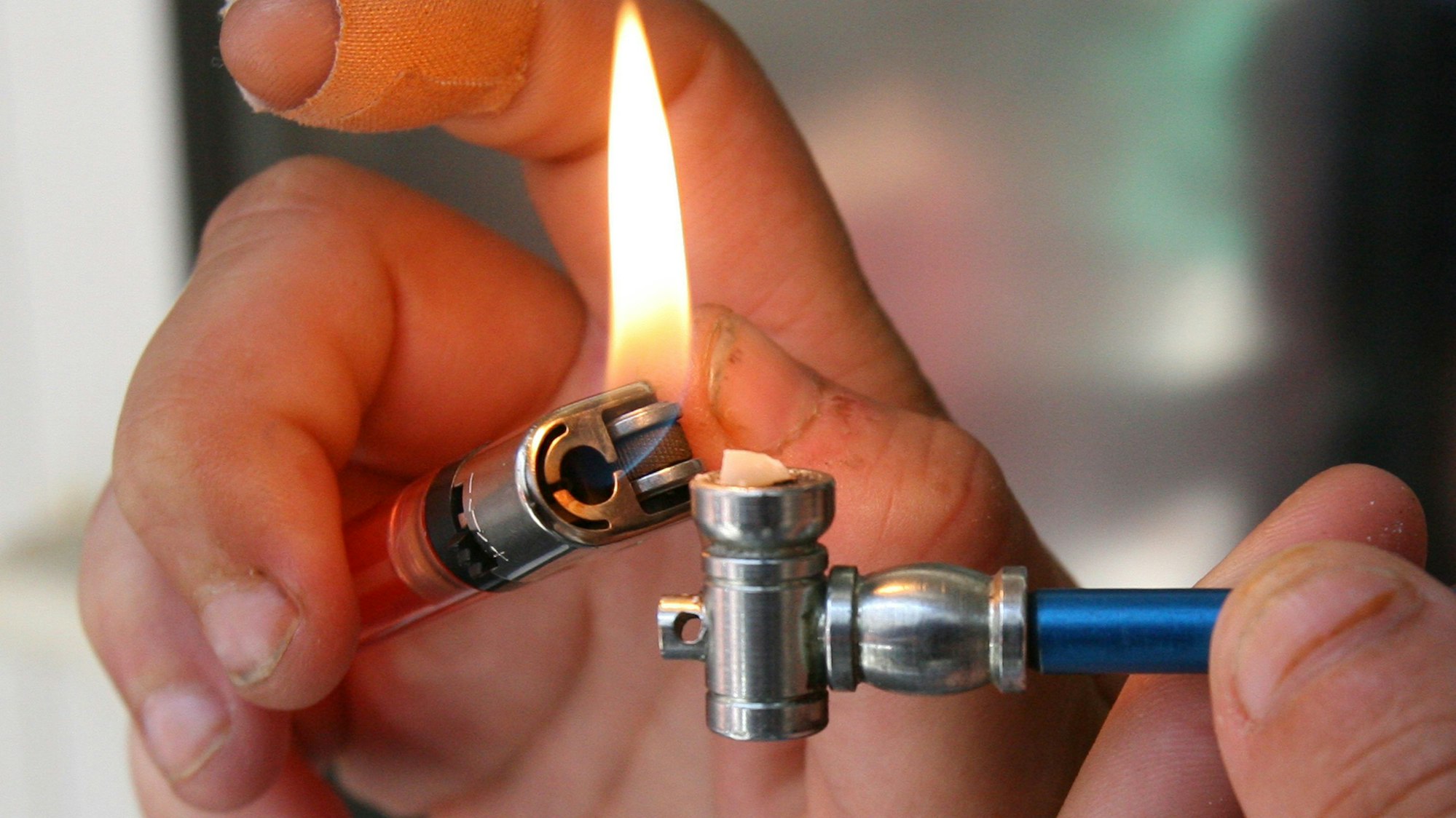 Eine Person zündet sich eine Crack-Pfeife an.