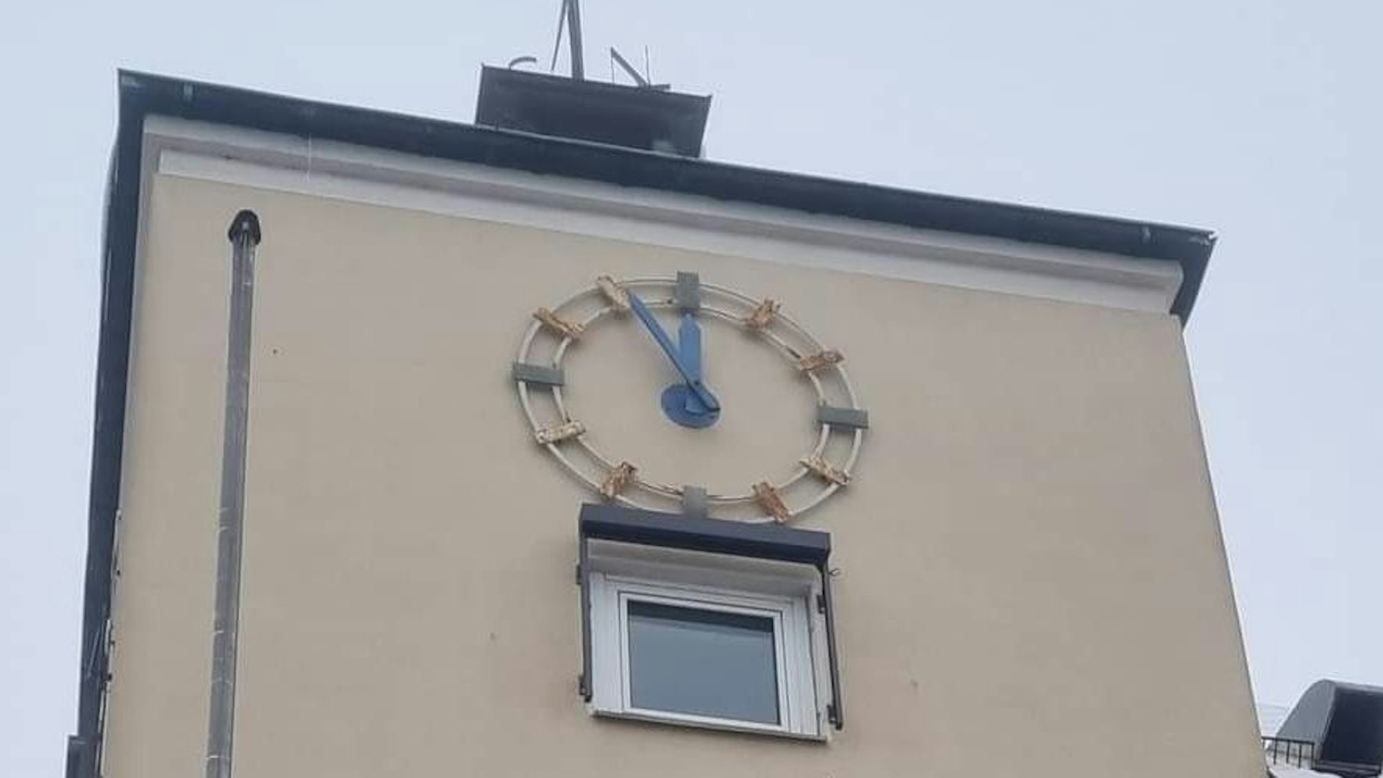 Die Zeiger einer großen Rathausuhr stehen auf fünf vor zwölf.