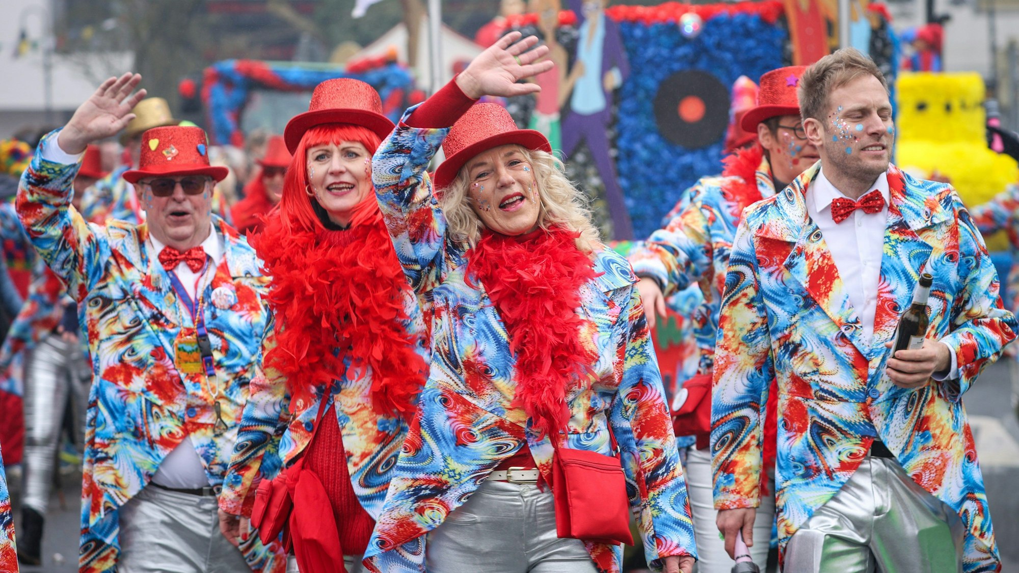 12.02.2023, Niedersachsen, Damme: bunt verkleidete Teilnehmer des Dammer Carnevals winken beim Straßenkarnevalsumzug durch den Ort.