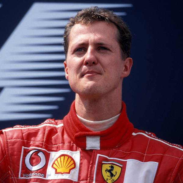 Der ehemalige Formel-1-Pilot Michael Schumacher schaut vor einem Werbebanner in die Ferne.