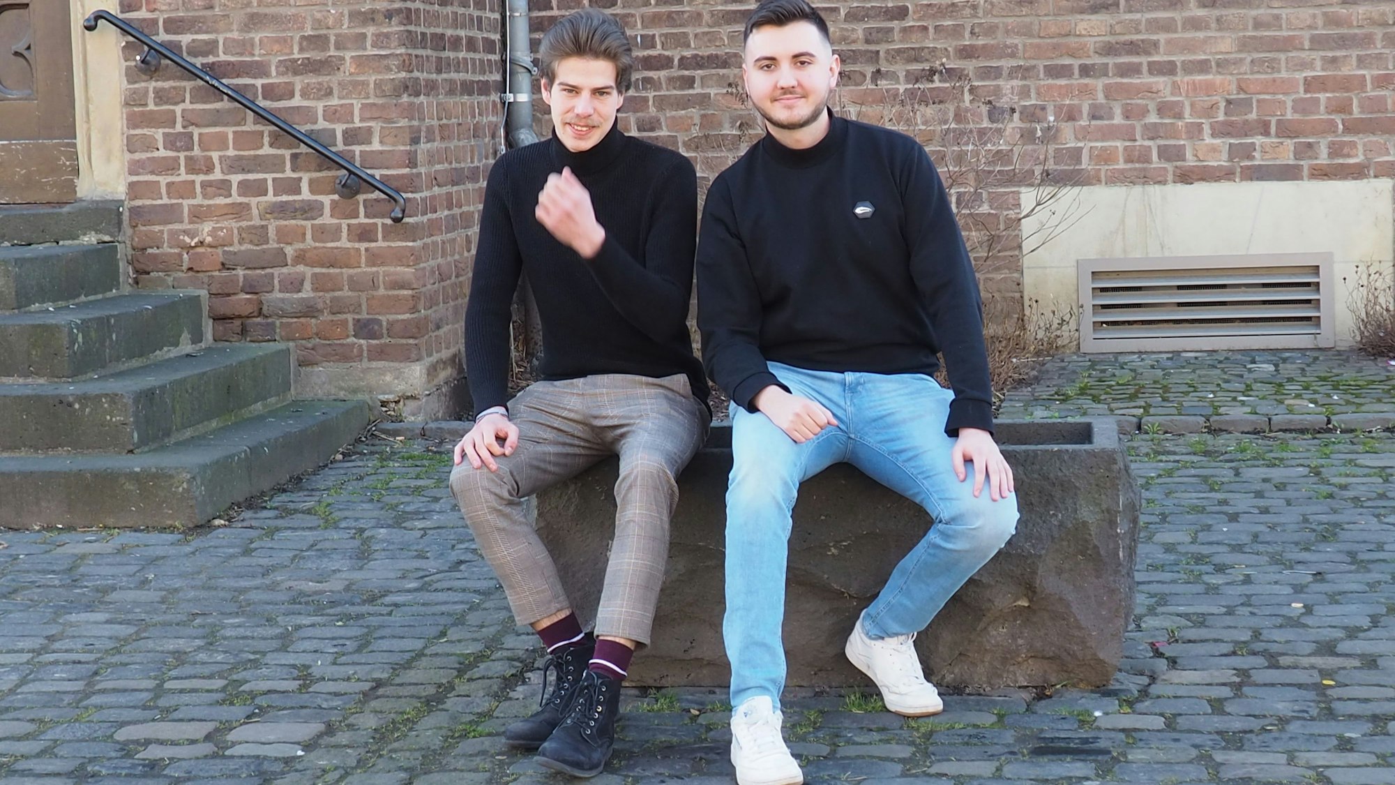 Raphael Wronka und Parteivorsitzender Erik Voigt sitzen auf einem Steinblock