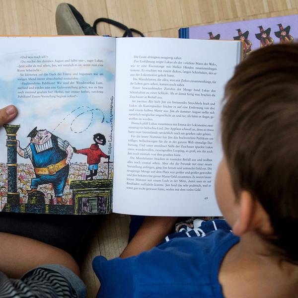 Zwei Jungen lesen das Kinderbuch „Jim Knopf und Lukas der Lokomotivführer“