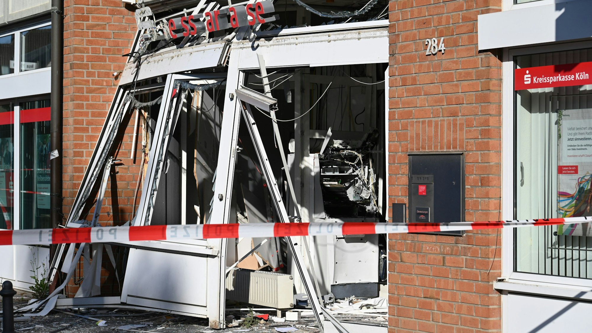 Ein zerstörter, explodierter Geldautomat an der Dürener Straße hinter rot-weißem Absperrband.