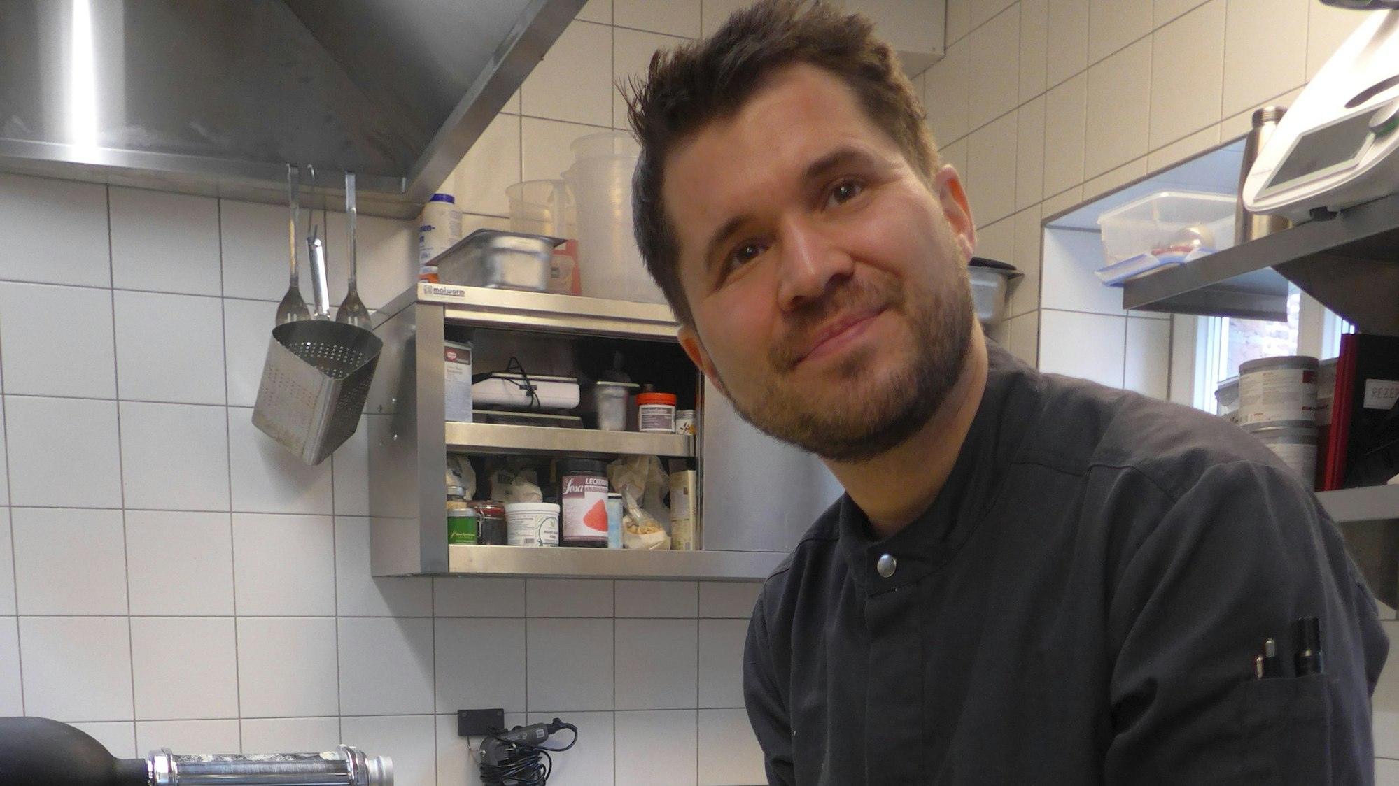 Das Foto zeigt den Koch Christof Hölscher . Er empfiehlt einen Bagel mit Frischkäse, Spinatsalat, Räucherlachs, Spiegelei und Sauce Hollandaise.