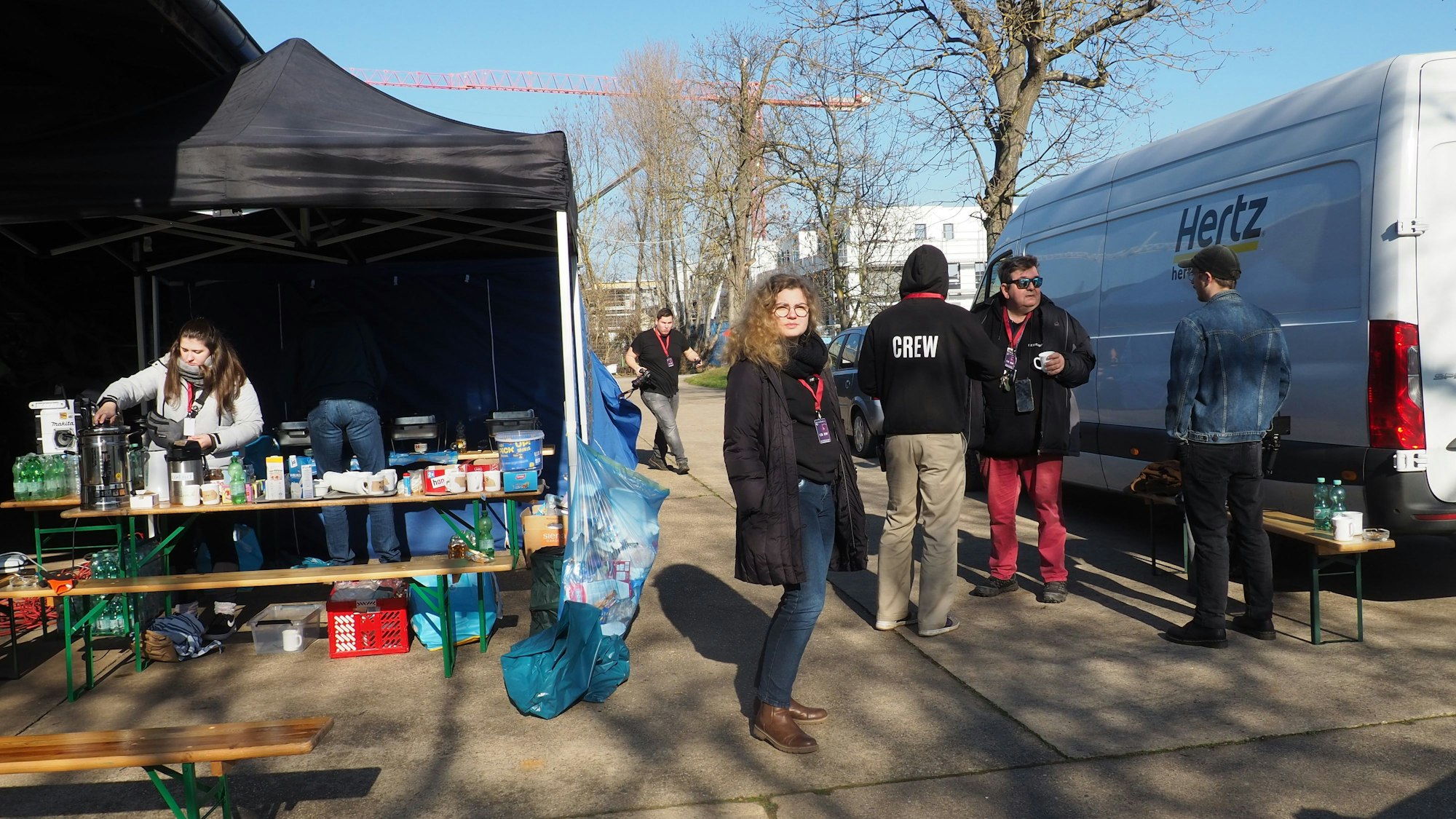 Mitglieder der Crew stehen auf dem Parkplatz und bereiten das Catering vor.