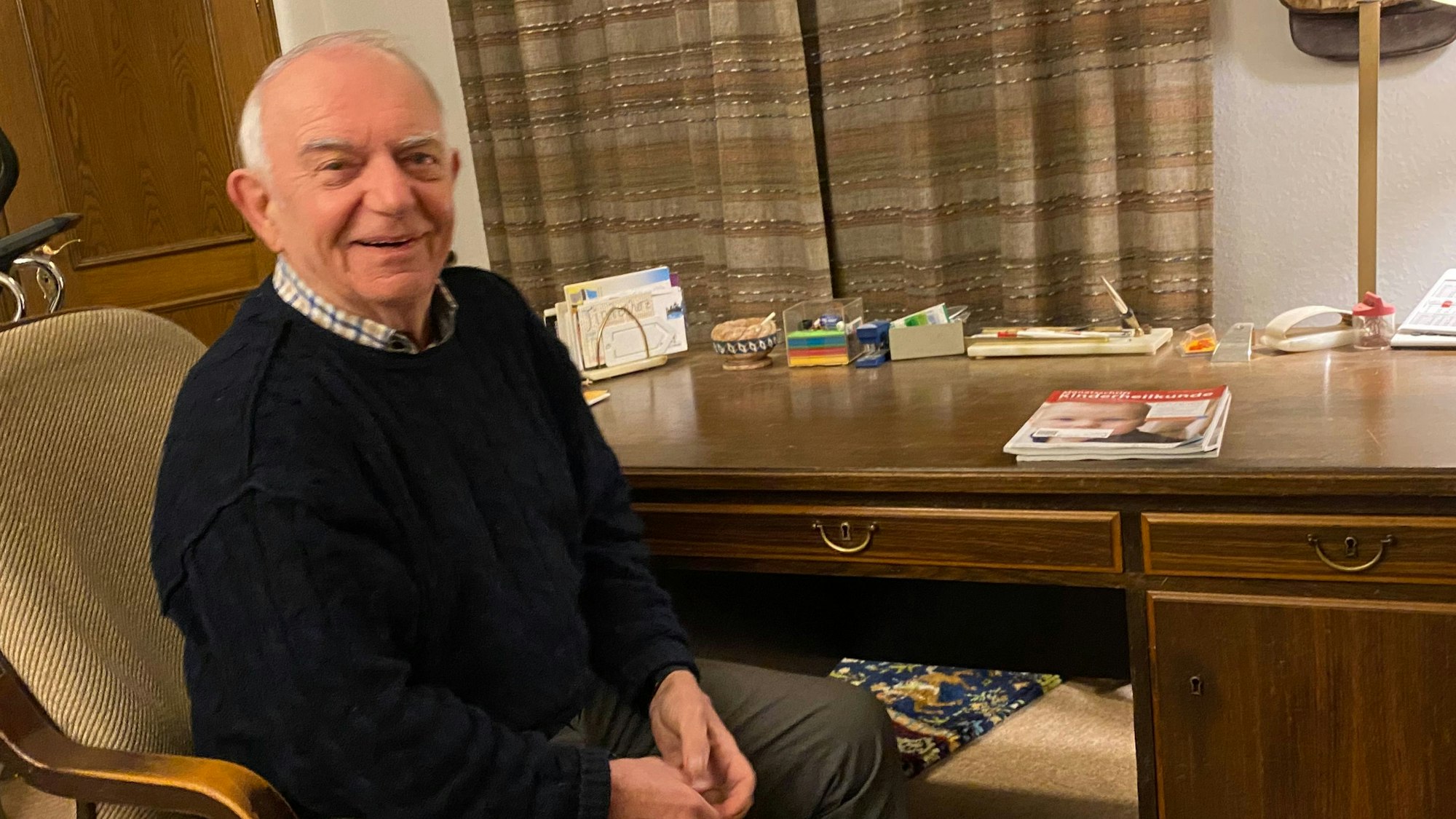 Der pensionierte Arzt Dr. Jörg Schriever sitzt an seinem Schreibtisch.