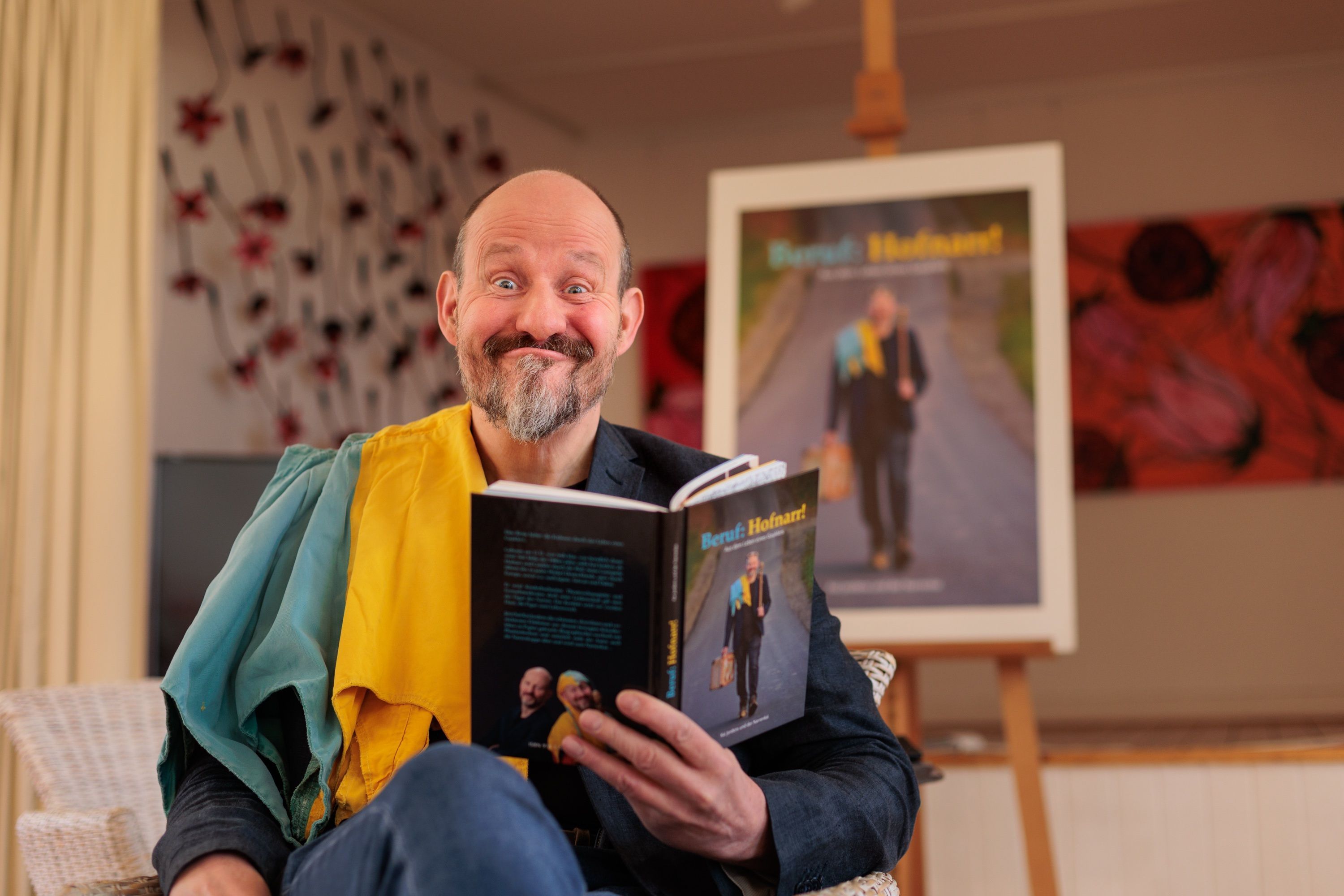 Kai Jordens schneidet eine Grimasse, während er sein Buch hält.