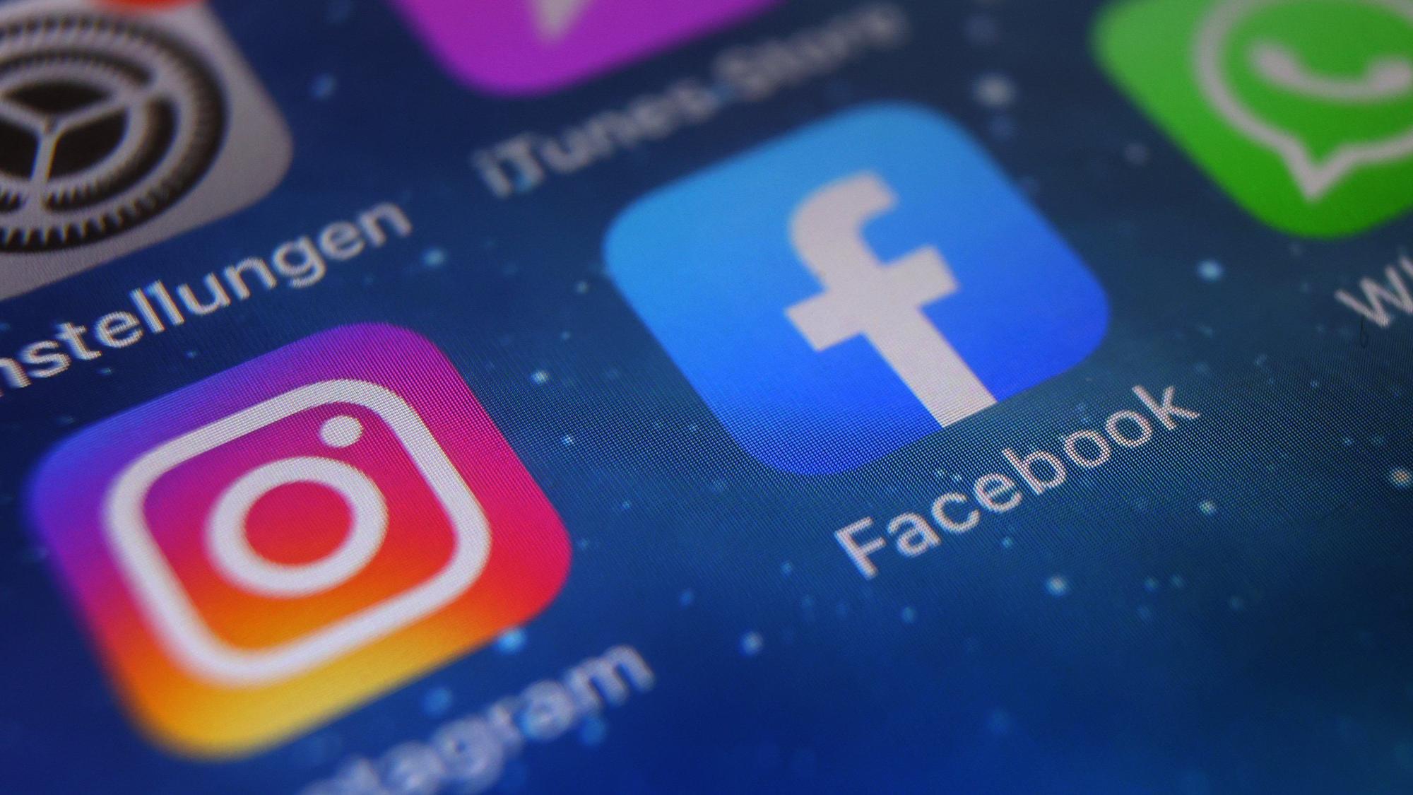 Auf dem Bildschirm eines Smartphones sind die Icons von Instagram, Facebook und WhatsApp zu sehen.