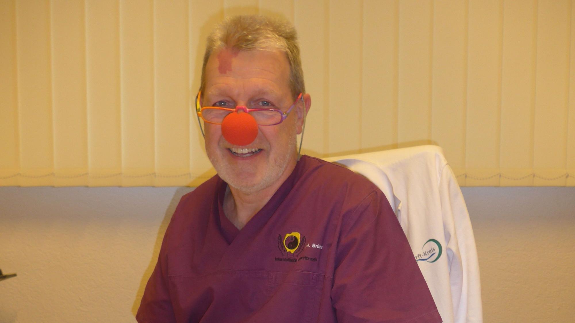 Auf dem Foto ist Dr. Albert Brüne zu sehen. Der Arzt trägt eine rote Clownsnase.