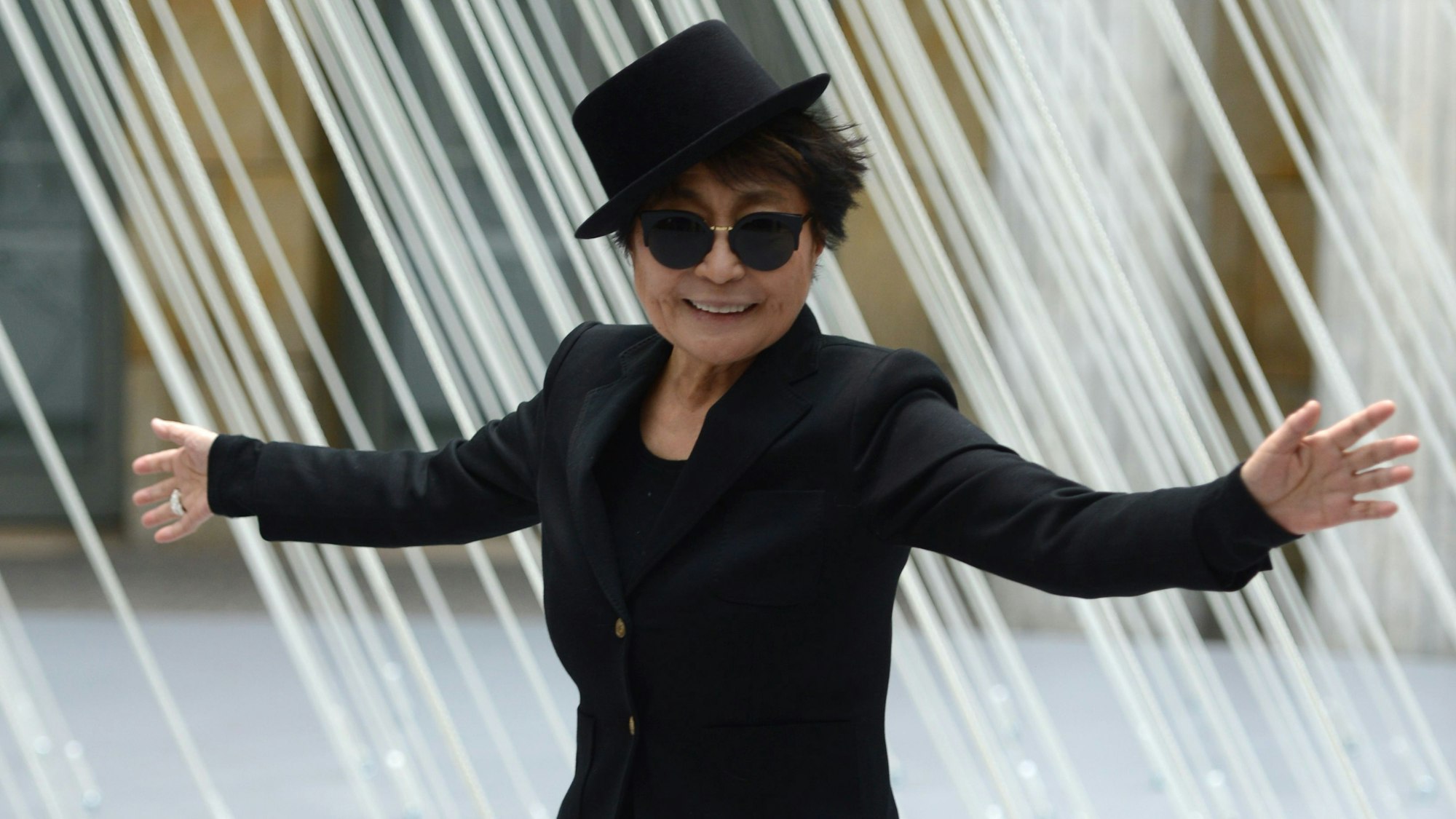 Yoko Ono ganz in Schwarz mit Hut.